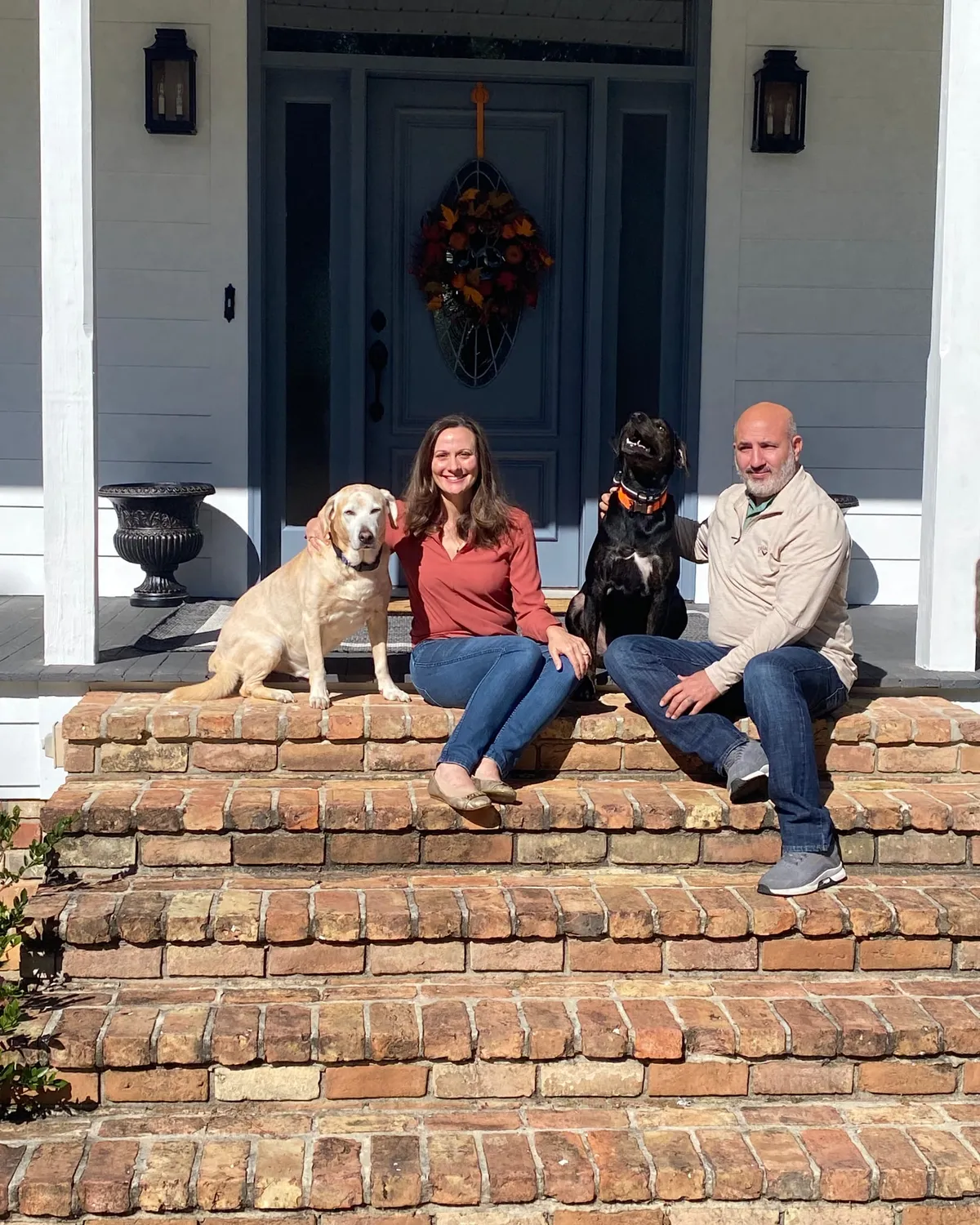 Jessica, Jason, Andy, and Charlie on the brick front steps of their Covington home, slate-blue door behind them